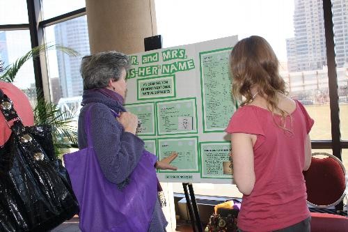Student explains poster presentation to another conference participant